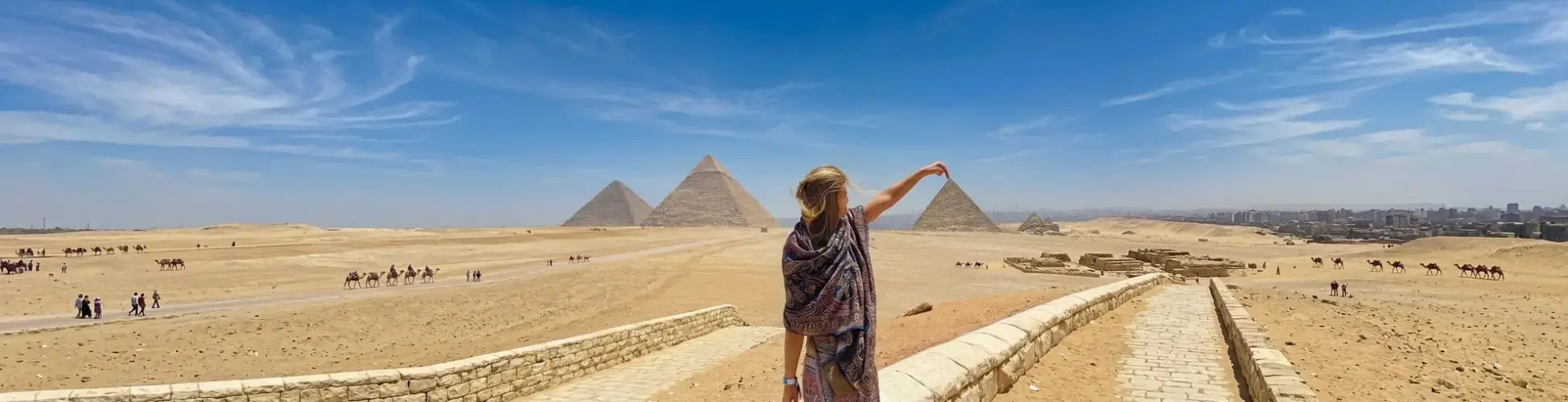 A traveler exploring the Giza Pyramids during warm sunny weather in Egypt in November