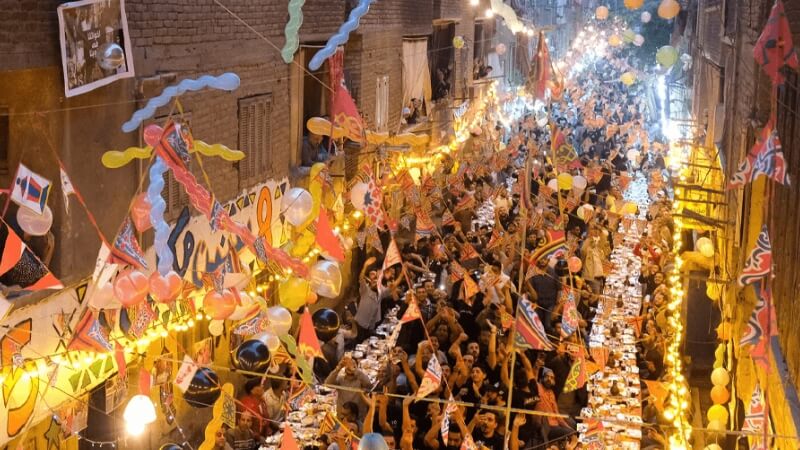 Crowded Egyptian street with families and friends sharing iftar during Ramadan